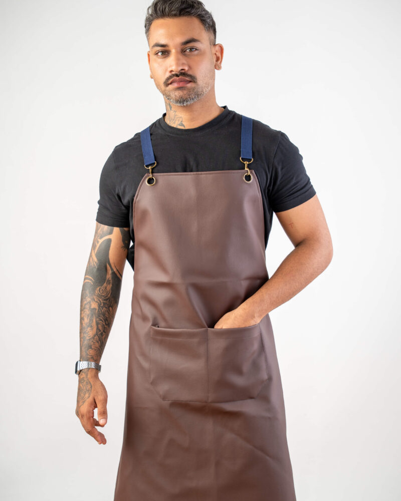 brown faux-leather bib apron, navy web straps + brass hardware