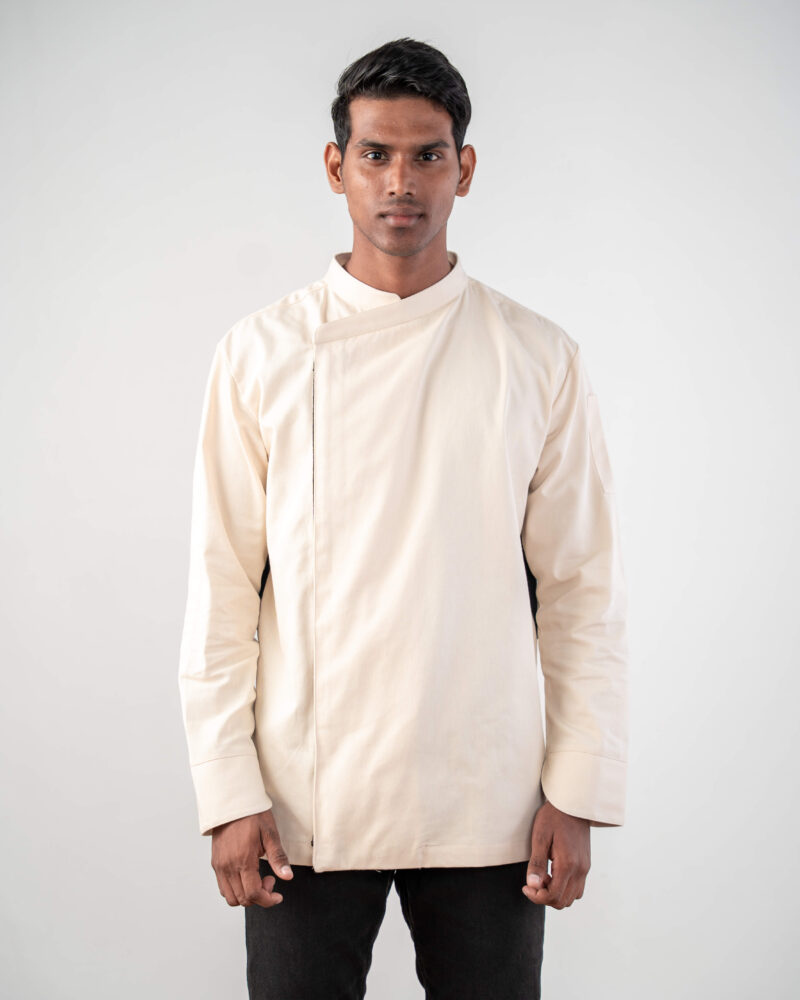 Model wearing a cream chef's jacket with black mesh ventilation panels along the sides and underarms