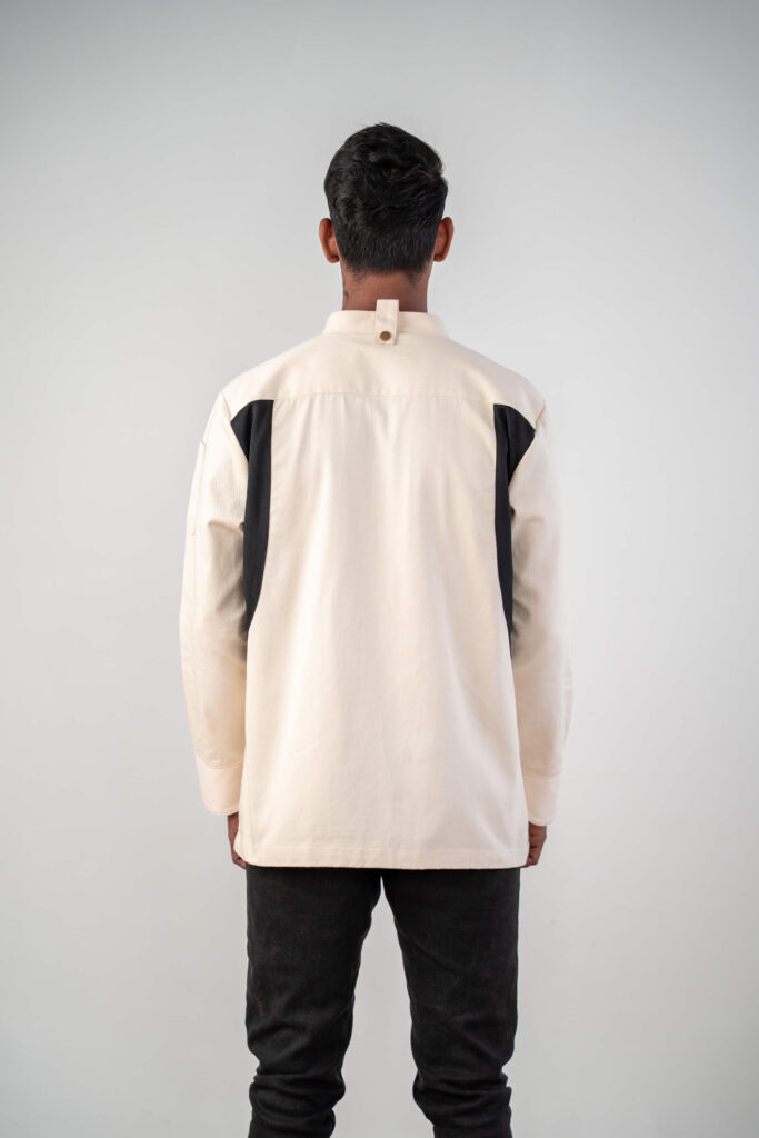 Model wearing a cream chef's jacket with black mesh ventilation panels along the sides and underarms